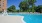 Large sparkling blue pool with a large pool deck and lounge chairs