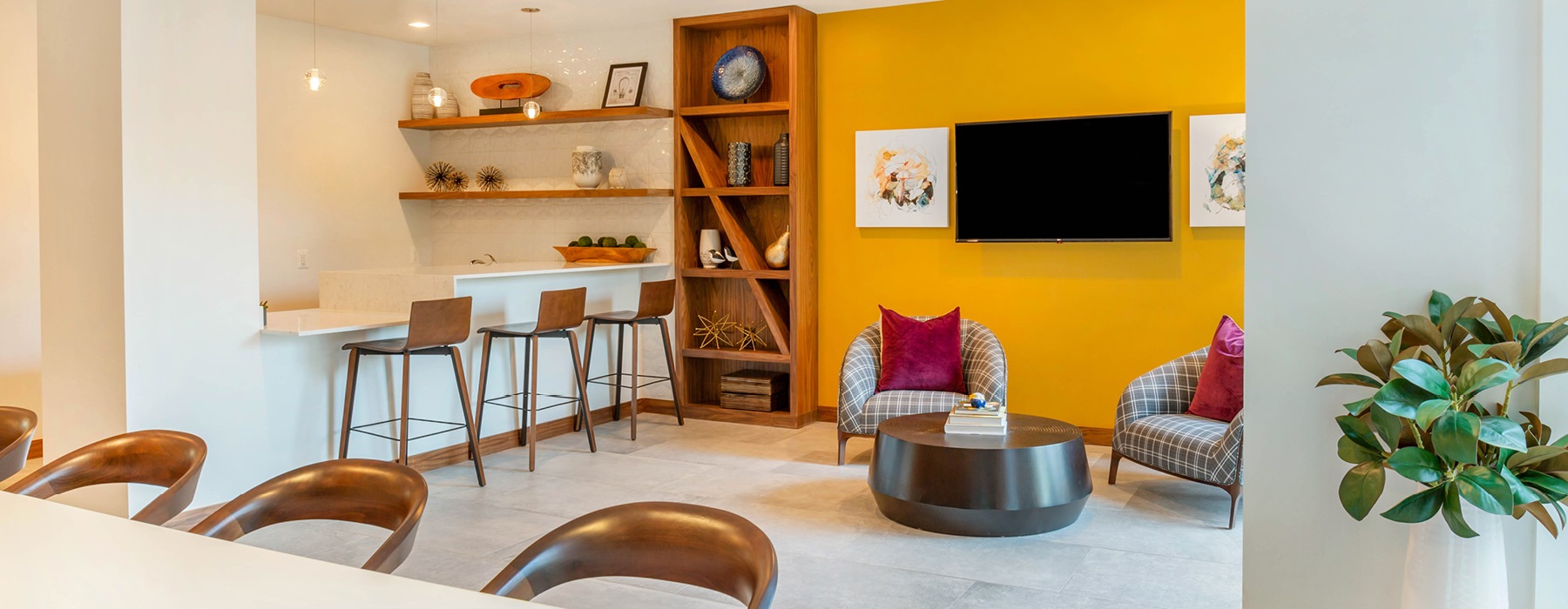 bright clubroom with social seating areas and kitchen